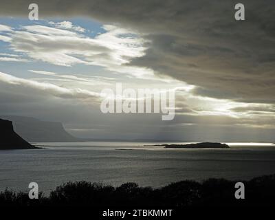 atmospheric seascape with spotlights of sunshine breaking through evening clouds on the craggy coast of the Isle of Mull, Scotland,UK Stock Photo