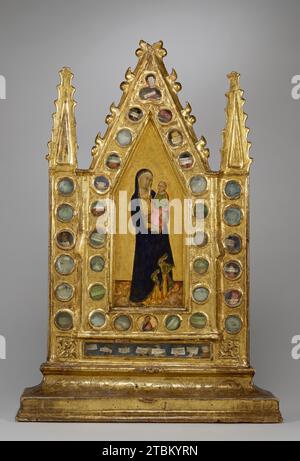 Reliquary Tabernacle with the Virgin and Child, c1350. The object's thirty-four clear glass windows, enamel-like colors, and gilded architecture give it the appearence of a sacred vessel fashioned from precious materials. The gabled enclosure around the central painting of Christ and the Virgin explicitly draws on forms usually associated with tabernacles or shrines that were erected over an altar to display relics or the consecrated Host. The frame, covered with gold leaf, suggests the shape of a chapel filled with heavenly light and contains saints' relics within glass-covered cavities. Each Stock Photo