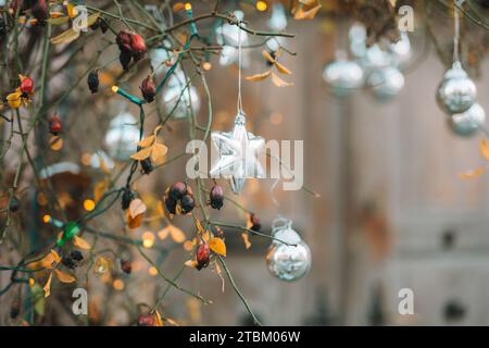 Metallic silver street decor. balls and stars, shining garlands on tree branches on winter city streets. Christmas season in Europe. Winter holiday Stock Photo