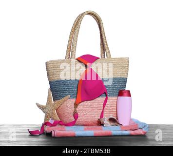 Stylish bag, starfish and other beach accessories on wooden table against white background Stock Photo