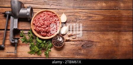 https://l450v.alamy.com/450v/2tbm61x/manual-meat-grinder-beef-mince-peppercorns-onion-and-parsley-on-wooden-table-flat-lay-banner-design-with-space-for-text-2tbm61x.jpg