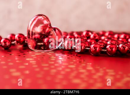 Shining transparent heart and a group of red beads. Perfect Valentine's Day greeting card background Stock Photo