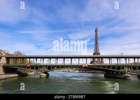 Eiffel Tower against blue sky with clouds and a bridge Pont de Bir-Hakeim (pont de Passy) over Seine River. Paris France. April 2019 Stock Photo