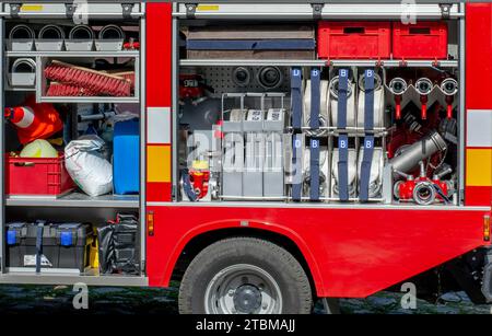 The side view of equipment inside of a fire engine. Fire truck with open hatches showing rescue equipment Stock Photo