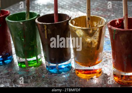 Glasses and brushes used for paint with brushes in them Stock Photo