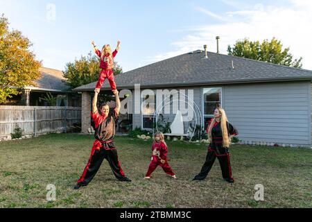Fort Worth, USA. 18th Nov, 2023. David Saucedo (L, below) and his wife Angela Saucedo (R) practice Wushu with their children at the backyard of their home, in Fort Worth, Texas, the United States, Nov. 18, 2023. TO GO WITH 'Feature: Love journey of U.S. Wushu family' Credit: Tian Dan/Xinhua/Alamy Live News Stock Photo