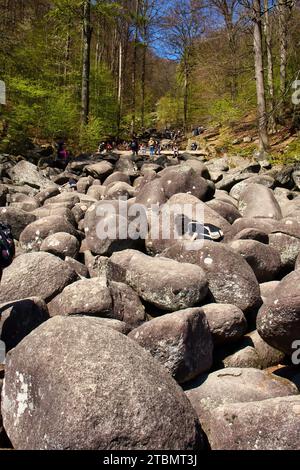 Lautertal, Germany - April 24, 2021: People climbing on large rocks at Felsenmeer on a spring day in Germany. Stock Photo