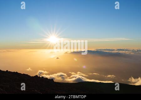 Sunset from above the clouds at the top of Haleakalā Volcano on Maui, Hawaii Stock Photo