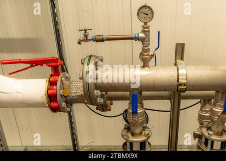 The interior of a mechanical room and a domestic potable water system with valves and connecting pipes. Stock Photo