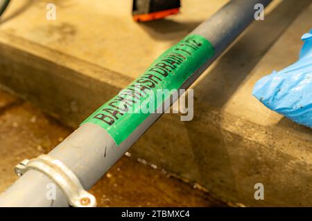 The interior of a mechanical room and a domestic potable water system with valves and connecting backwash drainage pipes. Stock Photo