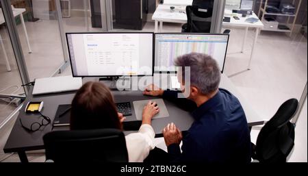 Working Analyst at Desktop PC with Multiple Spreadsheets Stock Photo