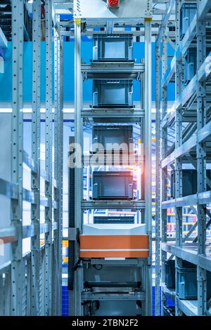 logistic warehouse storage facility with automated guided vehicles forklift lifting carton in modern warehouse. Stock Photo