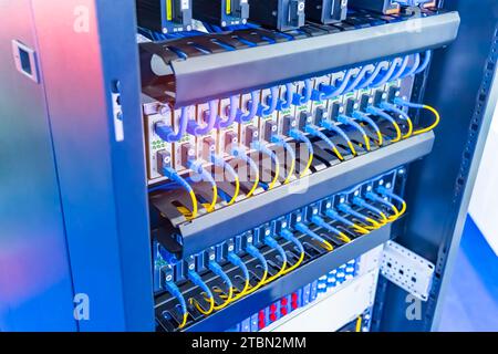 Fiber Optic cables connected to an optic ports and Network cables connected to ethernet ports. Stock Photo