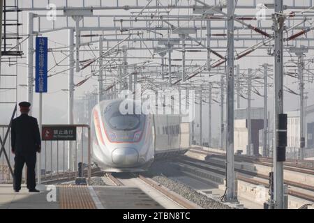 YANTAI, CHINA - DECEMBER 8, 2023 - A Fuxing EMU train runs on Laixi-Rongcheng High-speed Railway at Haiyang Station in east China's Shandong province, Stock Photo