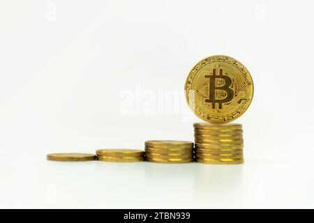 Golden coins with bitcoin symbol on a stack of coins over white background. The concept of profit growth from bitcoin trading. Bitcoin coin on a white Stock Photo