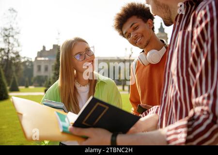 Group of cheerful students sharing good news discussing exam results Stock Photo