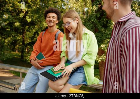 Confident smiling university students chatting together while taking rest Stock Photo
