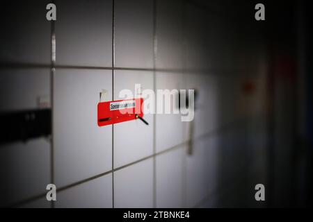 Note on wall in an empty tiled room with the German word Speisenauslieferung - food distribution. Stock Photo