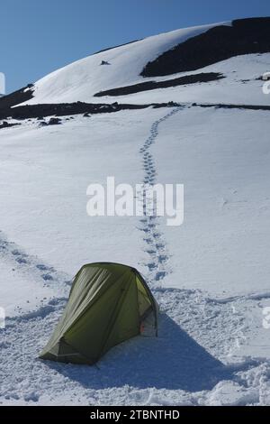 campsite in snowy mountainside of Mount Etna North-East Crater in winter, Piano Provenzana, Sicily, Italy Stock Photo