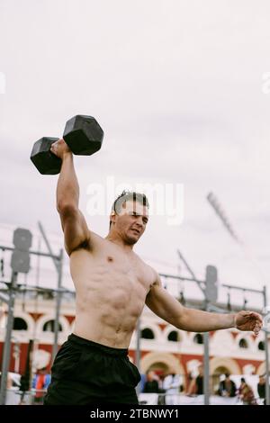 Men's CrossFit competition. A man lifts a dumbbell. Stock Photo