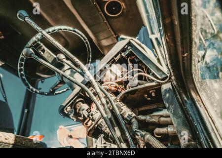 Inside view of cabin of old tractor. Levers and steering wheel. Outdated agricultural machinery.  Stock Photo