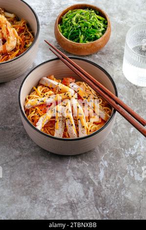 wheat Asian noodles with vegetables, sauce and chicken Stock Photo