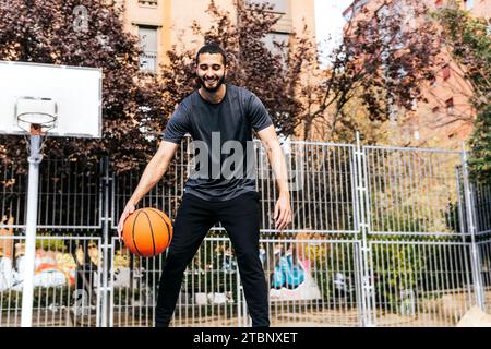 a person playing with a basketball on the court Stock Photo