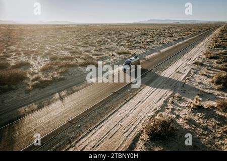 Camper van RV drives on long straight open road in Texas. Stock Photo