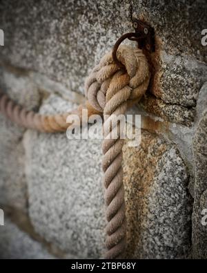 A rope knot on the sea wall Stock Photo