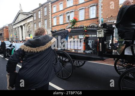 Flowers are thrown at the hearse as the funeral procession of Shane MacGowan makes its way through the streets of Dublin ahead of his funeral in Co Tipperary. The songwriter, who found fame as the lead singer of London-Irish punk/folk band The Pogues, died at the age of 65 last week. Picture date: Friday December 8, 2023. Stock Photo