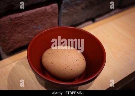 A raw brown unpeeled egg in a Japanese bowl. Stock Photo