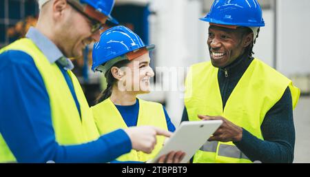 Engineers working at new AI prototype inside robotic factory - Future, job and technology concept - Main focus on center woman face Stock Photo