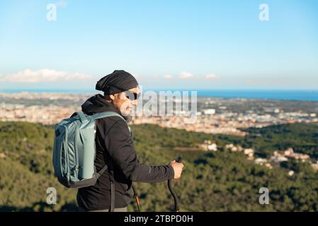 Middle-aged man contemplates the landscapes of the Garraf Natural Park while walking along the trails of a mountain. Stock Photo