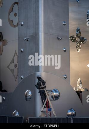 Paris, France - 12 06 2023: Champs-Elysees avenue. View of the detail of the facade of Louis Vuitton with christmas decoration and a worker on a stepl Stock Photo