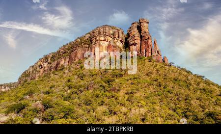 A stunning, sun-drenched landscape featuring rocky terrain and lush green shrubbery Stock Photo