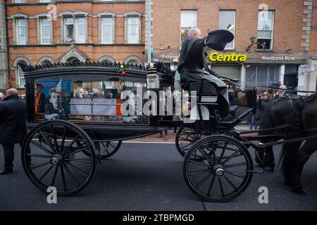 The funeral procession of Shane MacGowan stops briefly on Dublin's Westland Row as fans sing, Fairytale to New York, as it makes its way through the streets of the city ahead of his funeral in Co Tipperary. The songwriter, who found fame as the lead singer of London-Irish punk/folk band The Pogues, died at the age of 65 last week. Picture date: Friday December 8, 2023. Stock Photo