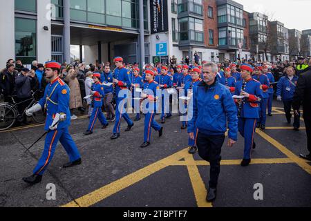 Members of the Artane Band lead the funeral procession of Shane MacGowan from Shelbourne Park Stadium as it makes its way through the streets of Dublin ahead of his funeral in Co Tipperary. The songwriter, who found fame as the lead singer of London-Irish punk/folk band The Pogues, died at the age of 65 last week. Picture date: Friday December 8, 2023. Stock Photo