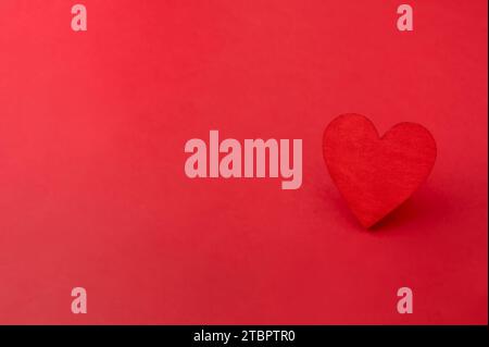 Red wooden heart on red background. Love, valentines day card Stock Photo