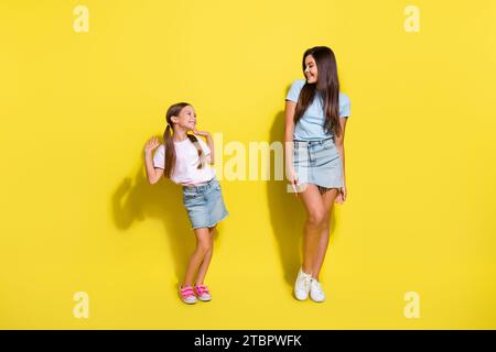 Photo of two cute girls sisters on family meeting events dancing isolated over shine color background Stock Photo