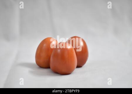 Tomatoes isolated on white background, Three fresh raw vegetables. Full depth of field. Side View Stock Photo