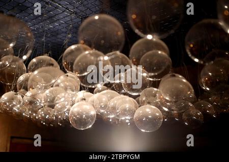 KYIV, UKRAINE - DECEMBER 7, 2023 - A ray of light illuminates glass balls hanging from the ceiling at the Christmas Factory of Dreams at the Expocente Stock Photo