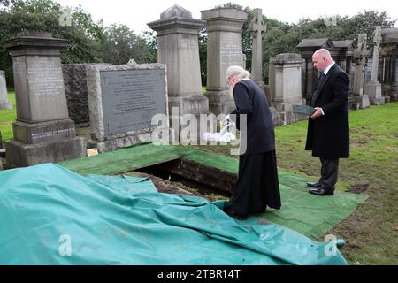 Glasgow Scotland Greek Orthodox Funeral at Glasgow Necropolis - Priest Pouring Olive Oil onto the Coffin at Committal Service Stock Photo