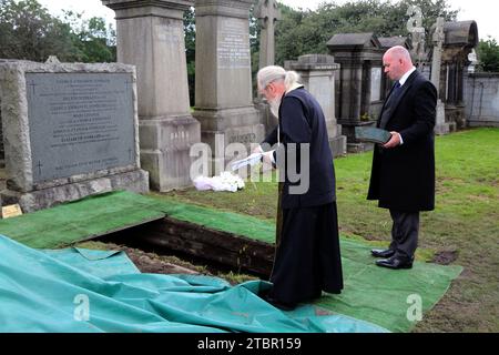 Glasgow Scotland Greek Orthodox Funeral at Glasgow Necropolis - Priest Pouring Olive Oil onto the Coffin at Committal Service Stock Photo