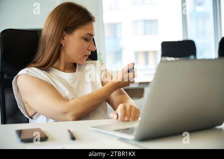 Young manager injects medicine into her arm Stock Photo