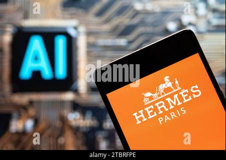 In this photo illustration, the French high fashion luxury clothing manufacturer Hermes logo seen displayed on a smartphone with an Artificial intelligence (AI) chip and symbol in the background. (Photo by Budrul Chukrut / SOPA Images/Sipa USA) *** Strictly for editorial news purposes only *** Stock Photo