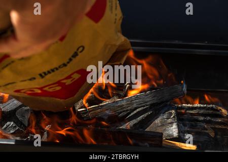 Barbecue grill pit with glowing and flaming hot open fire with red flame, hot charcoal briquettes and embers Stock Photo