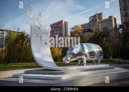 13 June Tbilisi flood tragedy memorial of silver hippo and white pigeons flying up to the blue sky, in Mziuri Park. Tbilisi, Georgia - December 04, 2023. Stock Photo