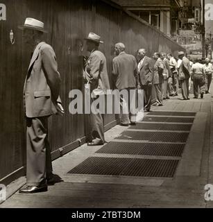 Row of men standing on sidewalk looking through round peep holes at new construction site, New York City, New York, USA, Angelo Rizzuto, Anthony Angel Collection, July 7, 1949 Stock Photo