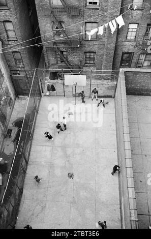 High angle view of Puerto Rican children playing basketball in courtyard surrounded by  buildings, Lower East Side, near 4th Avenue and Forsythe Street, New York City, New York, USA, Marion S. Trikosko, U.S. News & World Report Magazine Photograph Collection, November 4, 1959 Stock Photo