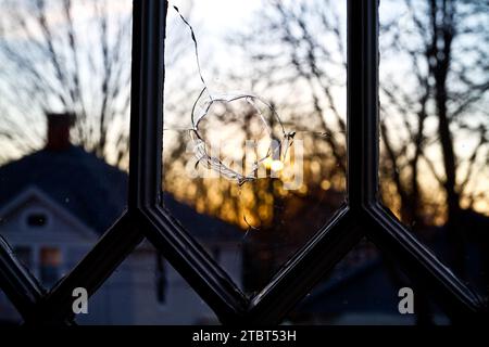 Golden Sunset through Broken Glass Window in Suburban Home at Sunset Stock Photo